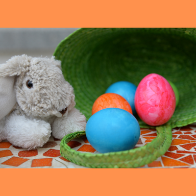 Handful of colorful eggs spilling out of green Easter basket and gray stuffed bunny. Source: blickpixel from Pixabay